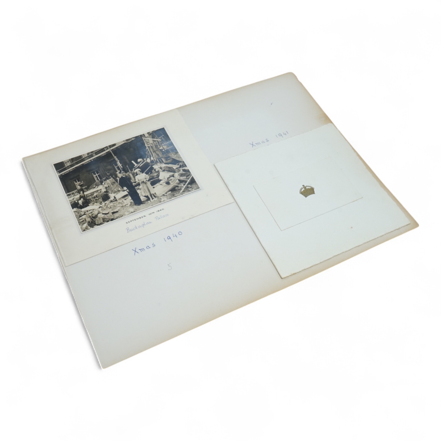 Two Royal Christmas cards; a card for Christmas 1940, the image used being a photograph of HM King George VI and Queen Elizabeth against a backdrop of the bomb damage at Buckingham Palace, dated ‘September 10th 1940’ (un